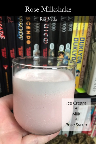A small clear drinking glass filled with a pink milkshake. Behind it, many CLAMP comics are visible, just out of focus. Overlay text lists the drink's name and basic ingredients.